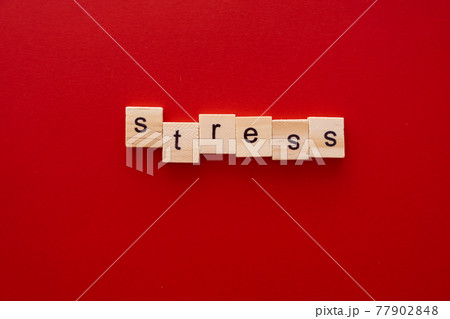 word STRESS made of wooden letters on red background with copy space 77902848