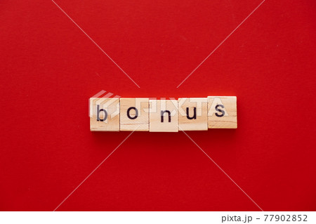 word BONUS made of wooden letters on red background with copy space 77902852