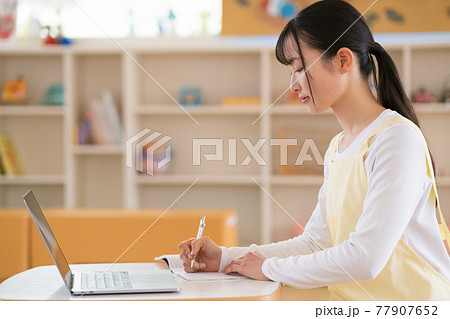 日誌を書く保育士 77907652