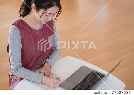 日誌を書く保育士 77907657