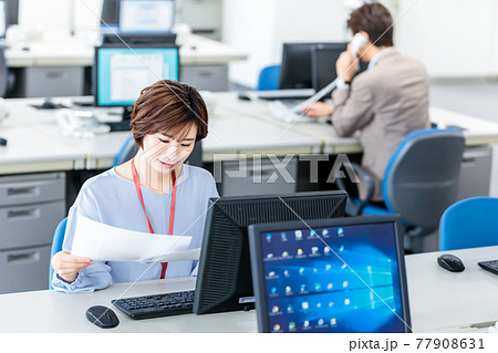 明るいオフィスでパソコンを使う若いビジネスウーマン 77908631