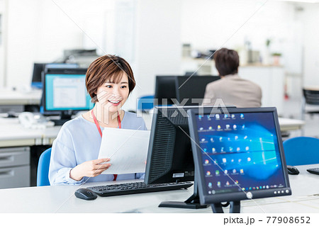 明るいオフィスでパソコンを使う若いビジネスウーマン 77908652