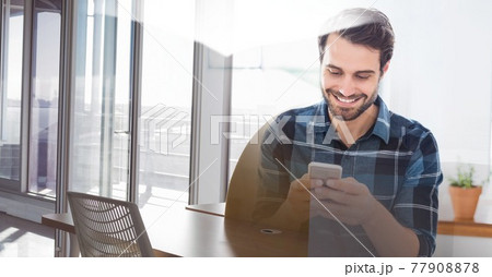 Composition of smiling man using smartphone in office with white overlay Composition of smiling man using smartphone in office with white overlay 77908878