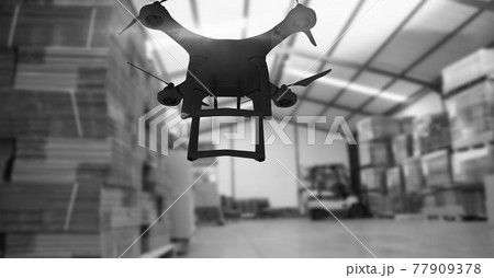 Drone flying over a warehouse in black and white, delivery and technology concepts Drone flying over a warehouse in black and white, delivery and technology concepts 77909378