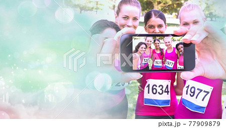 Composition of light circles over group of diverse sportswomen taking selfie with smartphone 77909879