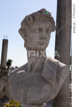 Ancient stone sculpture of man's bust in reclamation yard Ancient stone sculpture of man's bust in reclamation yard 77910337
