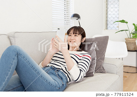ソファーでくつろぐ女性 77911524