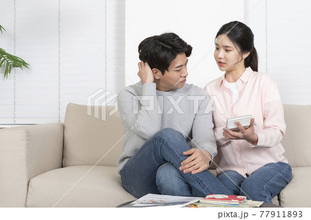 Asian newlyweds, couple managing home living expense concept, holding calculator Asian newlyweds, couple managing home living expense concept, holding calculator 77911893