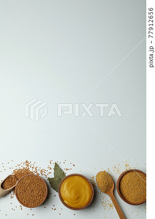 Bowls with mustard seeds, sauce and powder on white background Bowls with mustard seeds, sauce and powder on white background 77912656