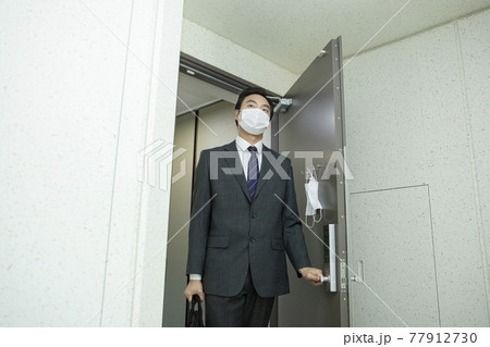 Asian business man in suit wearing mask before going out 77912730