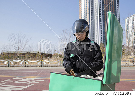 Asian delivery male courier on motorcycle, scooter delivering food, orders 77912995