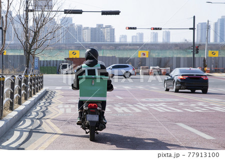 food delivery male courier riding motorcycle, scooter to deliver orders 77913100