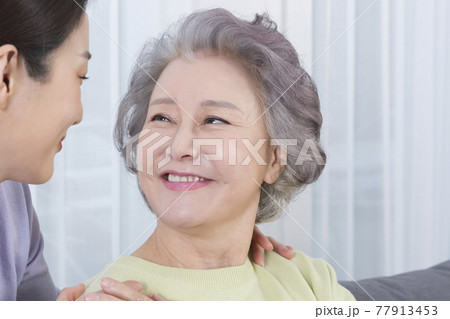 happy smiling Asian old mother and middle aged daughter on sofa happy smiling Asian old mother and middle aged daughter on sofa 77913453
