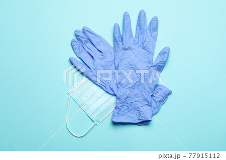 Medical gloves with mask on blue background Medical gloves with mask on blue background 77915112