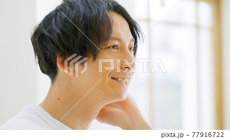 笑顔で髪を触る男性 笑顔で髪を触る男性 77916722