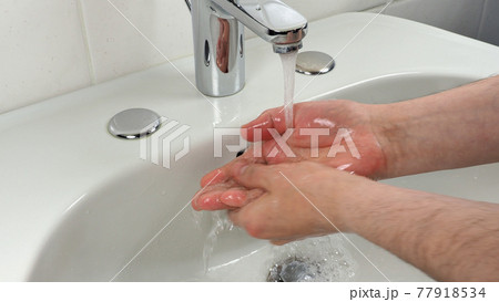 Unrecognisable man washing hands 77918534