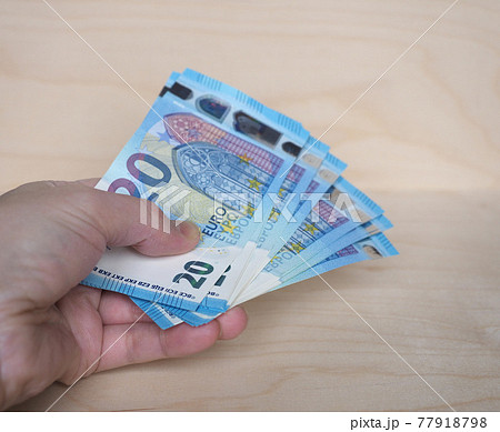 Hand holding Euro notes, European Union 77918798