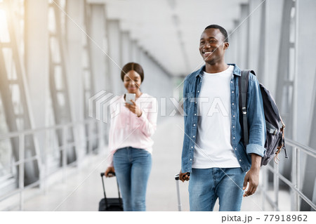 Air Travelling. Happy Smiling Black People Walking With Suitcases In Airport Terminal Air Travelling. Happy Smiling Black People Walking With Suitcases In Airport Terminal 77918962