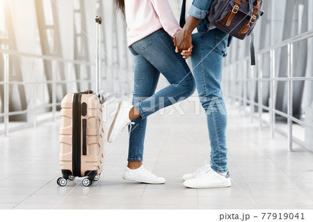 Cropped Shot Of Black Couple Holding Hands While Standing In Airport Terminal 77919041