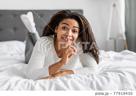 Black lady puting finger on lips, making hush sign Black lady puting finger on lips, making hush sign 77919430