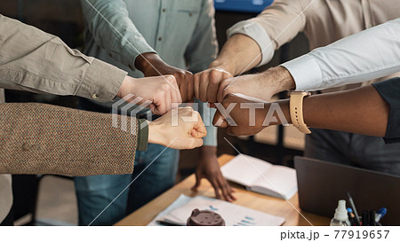 Portrait of diverse business people giving fist bump in circle 77919657