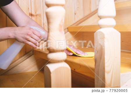 Woman hands cleans with napkin wooden stairs.  77920005