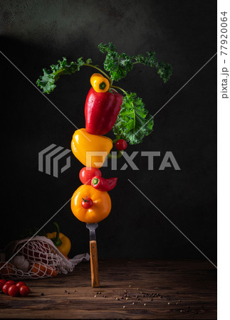 Fresh vegetables for summer soup piled up balancing on fork on the wooden table 77920064