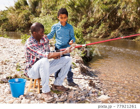 Man and boy fishing with rods Man and boy fishing with rods 77921261
