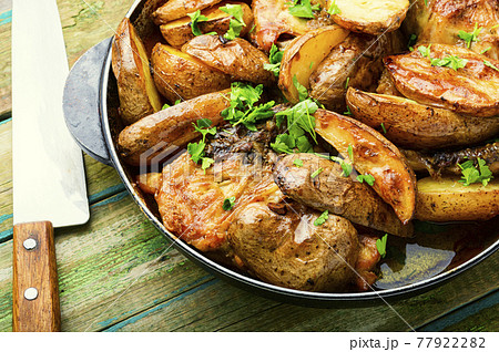 Chicken baked with potatoes in a pan 77922282