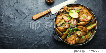 Roast chicken leg with potatoes on iron cast pan Roast chicken leg with potatoes on iron cast pan 77922283