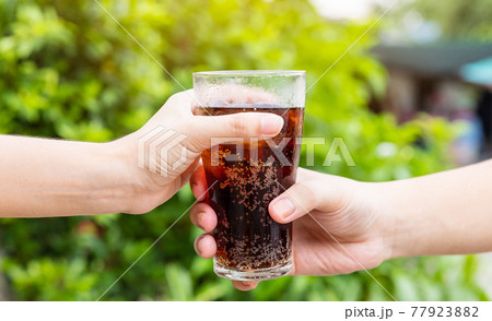 Men and Woman hand giving glass of cola.Glass of cola ,Soft drinks with ice, sweetheart or buddy 77923882