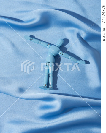Puppet on blue satin texture background as man swimming in ocean sea concept Puppet on blue satin texture background as man swimming in ocean sea concept 77924376