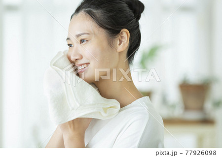 タオルで顔を拭く若い女性 77926098
