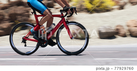 Road bike cyclist man cycling, athlete on a race cycle. Panning technique used Road bike cyclist man cycling, athlete on a race cycle. Panning technique used 77929760