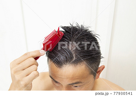 髪を染める男性の手元 77930541