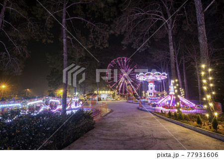 Spinning ferris wheel at night 77931606
