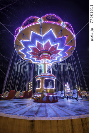 Swing ride at fair spinning around with people having fun Swing ride at fair spinning around with people having fun 77931611