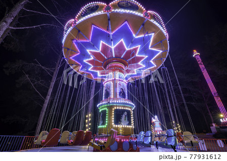 Swing ride at fair spinning around with people having fun Swing ride at fair spinning around with people having fun 77931612