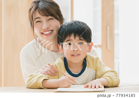 勉強する男の子と見守る母親 77934185