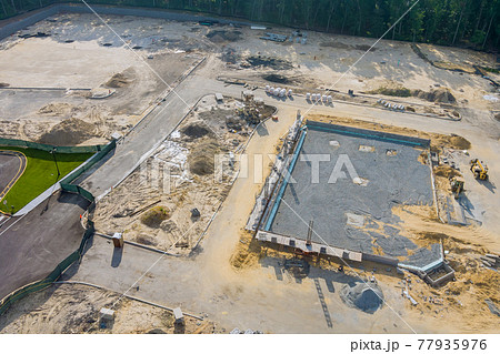 Preparation for a wall construction site, form blocks being filled with concrete 77935976