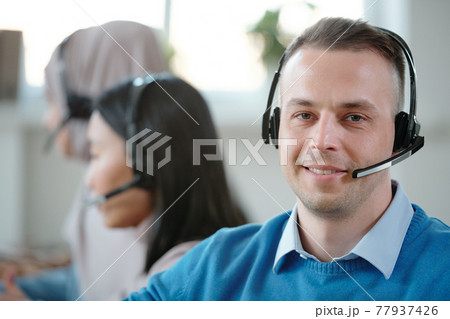 Portrait of positive young customer service representative Portrait of positive young customer service representative 77937426