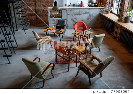 Several armchairs standing around tables in office Several armchairs standing around tables in office 77938064