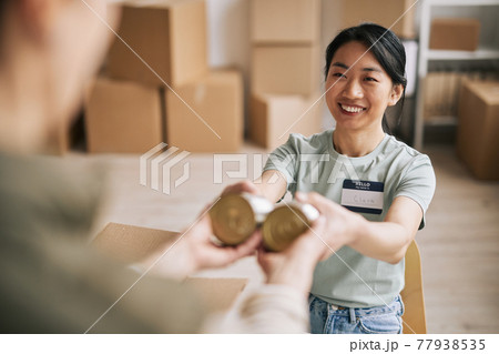 Smiling Young Woman Volunteering Smiling Young Woman Volunteering 77938535