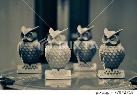 Four multicolored models of owls created on a 3d printer stand close-up 77942719