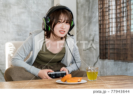 部屋でネットゲーム(オンラインゲーム)をプレイする女性 部屋でネットゲーム(オンラインゲーム)をプレイする女性 77943644