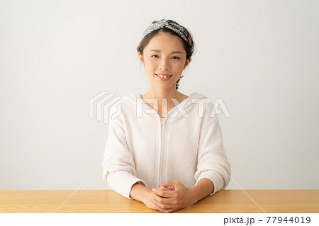 カメラ目線で微笑む若い女性 77944019