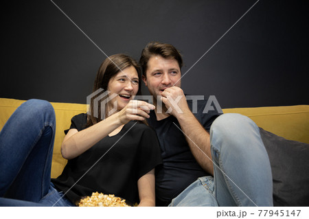 Love moments of happy young family. Joyful Couple watch Funny tv movie laughing 77945147
