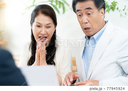 営業マンと商談する中高年カップル 77945924