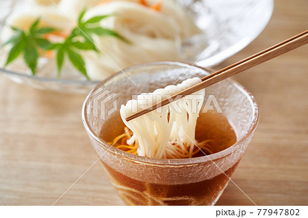 そうめんを麺汁につける 77947802