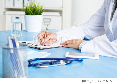 Doctor filling patient history list at clipboard Doctor filling patient history list at clipboard 77948151